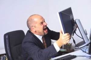 Mann rastet vor seinem Computer aus